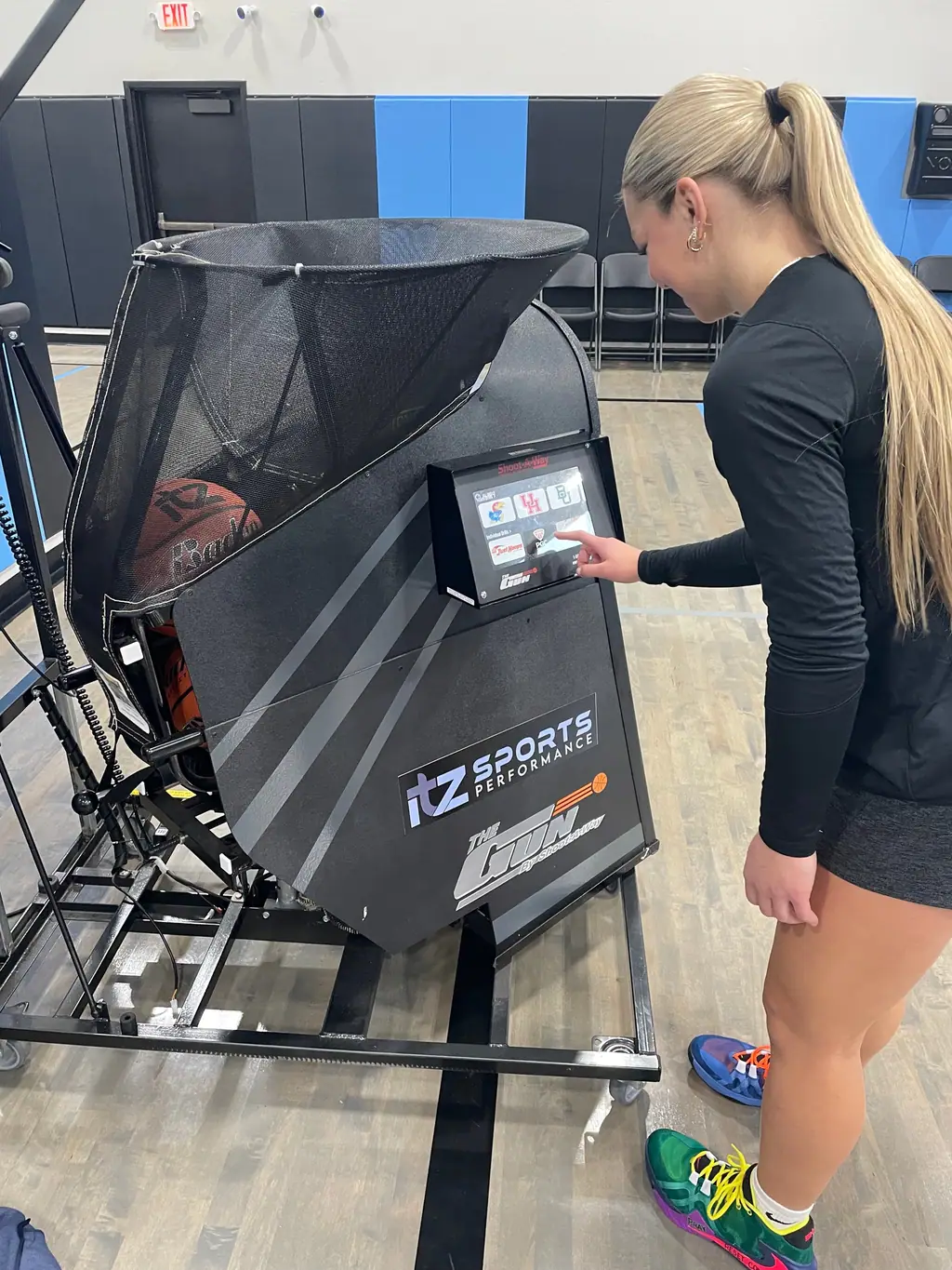 An athlete tapping the touchscreen on The Gun by Shoot-A-Way shooting machine
